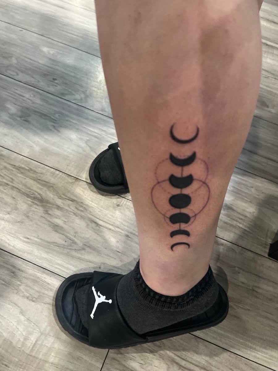Moon phase tattoo running down a calf